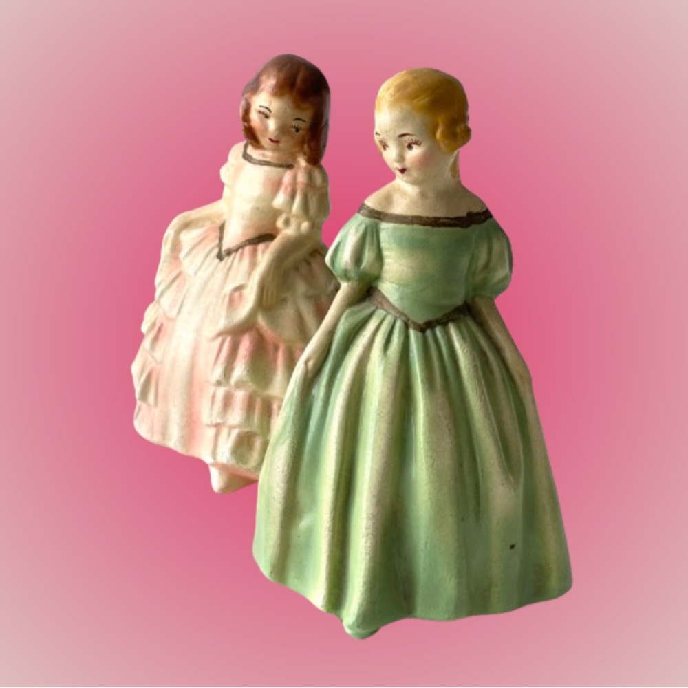 Two chalkware (?) girl figures in pink & green dresses side eye cottagecore